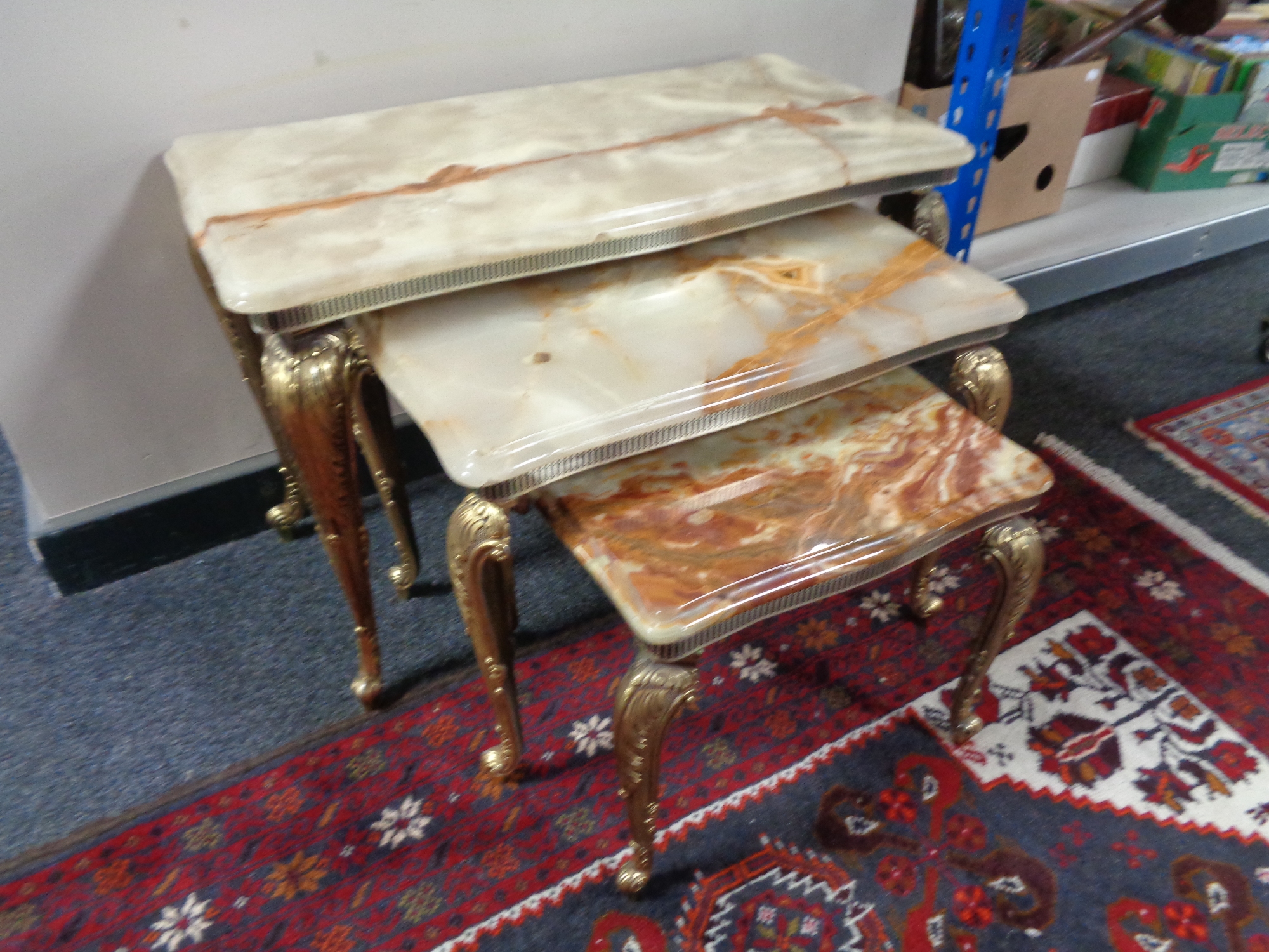 A nest of three onyx topped tables on gilt metal legs