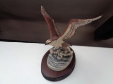 A Border Fine Arts figure of an osprey catching a fish on wooden stand