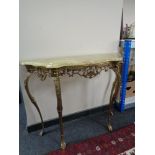A shaped ornate onyx console table on brass legs, height 78 cm, depth 35 cm, width 103 cm.