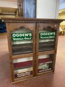 A Victorian oak double door bookcase bearing Ogden's Cigarettes advertisement