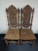 A pair of late Victorian heavily carved oak hall chairs