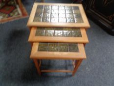 A nest of three teak tiled topped tables
