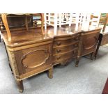 An antique mahogany serpentine fronted rail back sideboard fitted cupboards and drawers