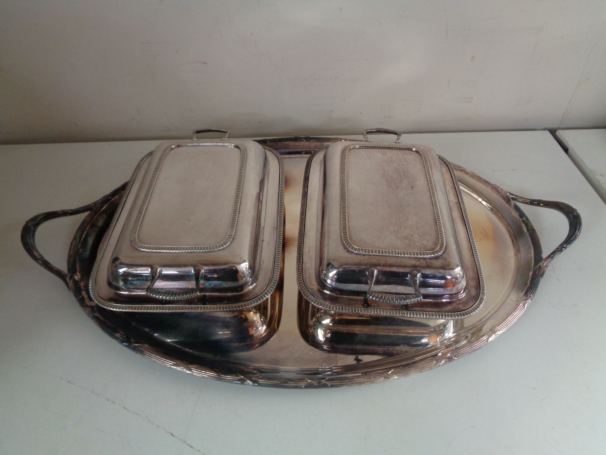 A silver plated twin-handled serving tray together with two lidded entree dishes