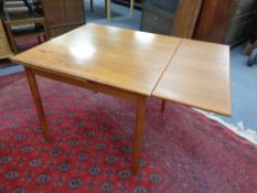 A mid 20th century teak pull out dining table