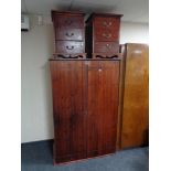 A stained pine double door wardrobe and pair of stained pine three drawer bedside chests