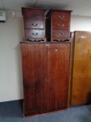 A stained pine double door wardrobe and pair of stained pine three drawer bedside chests