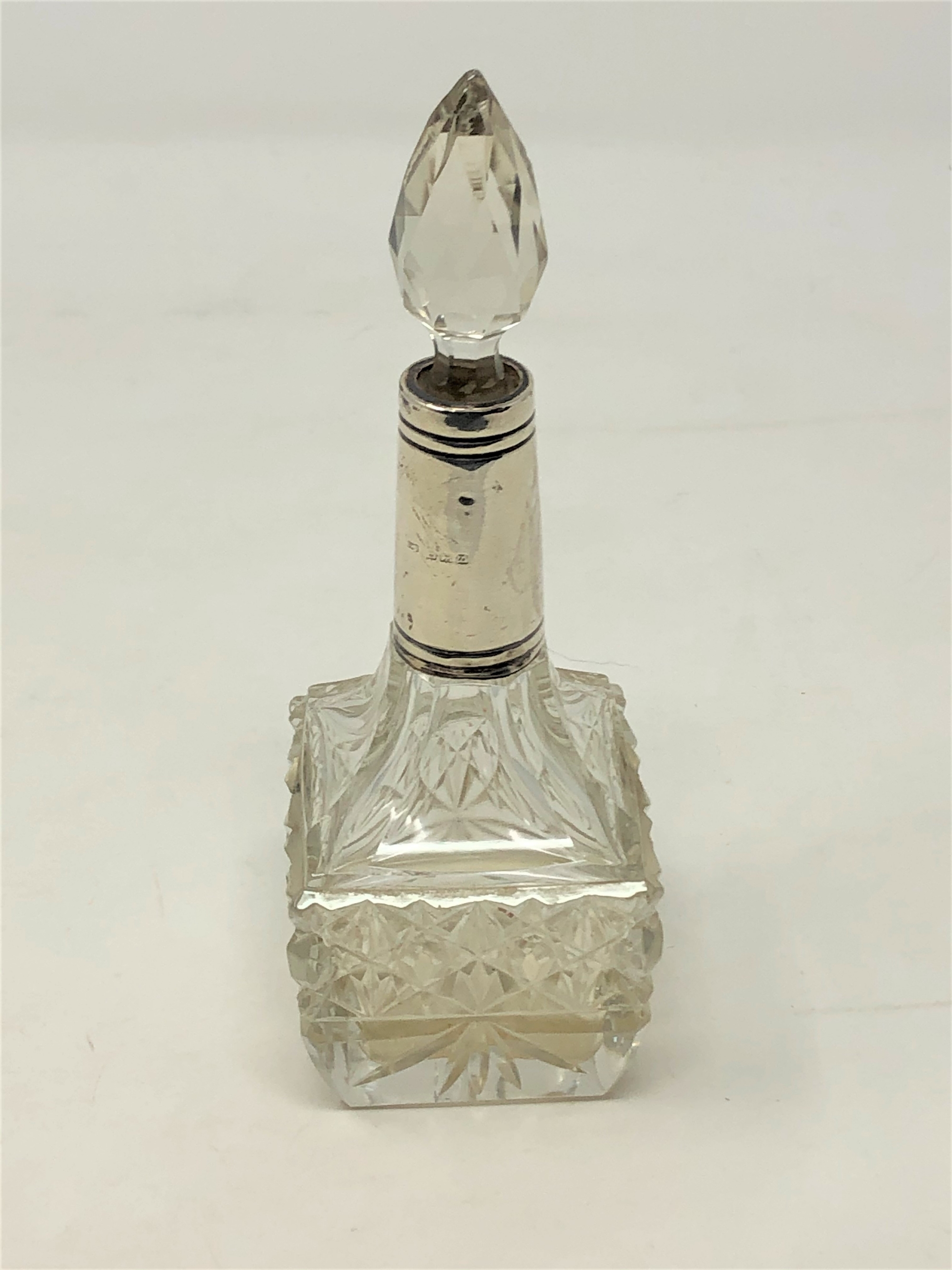 A silver-collared perfume bottle,