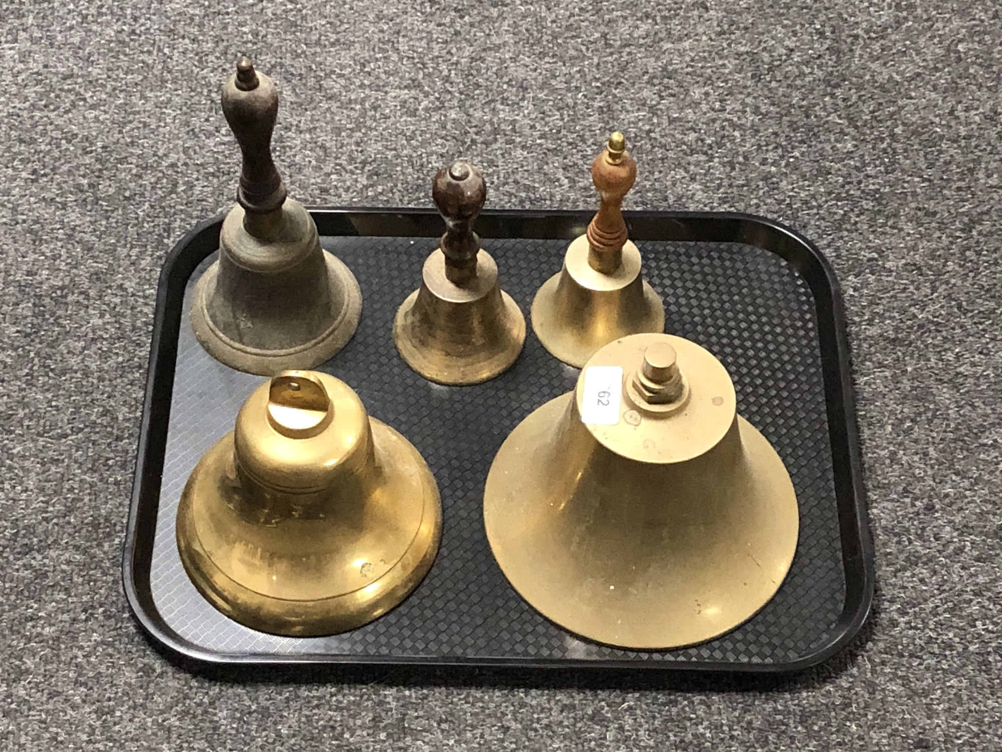 A tray of two brass ship's bells and two wooden handled bells