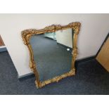 A 20th century gilt framed shaped wall mirror 56 cm x 68 cm