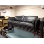 A 1970's Danish black leather three seater settee and two seater matching settee with footstool