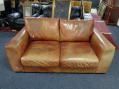 A pair of tan leather two seater settees