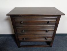 An Edwardian oak three drawer chest with knob handles