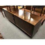 A mid 20th century low sideboard with shutter doors