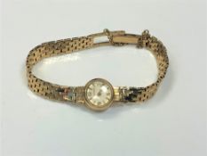 A lady's 9ct gold Jaeger-LeCoultre wristwatch on 9ct gold integral strap.