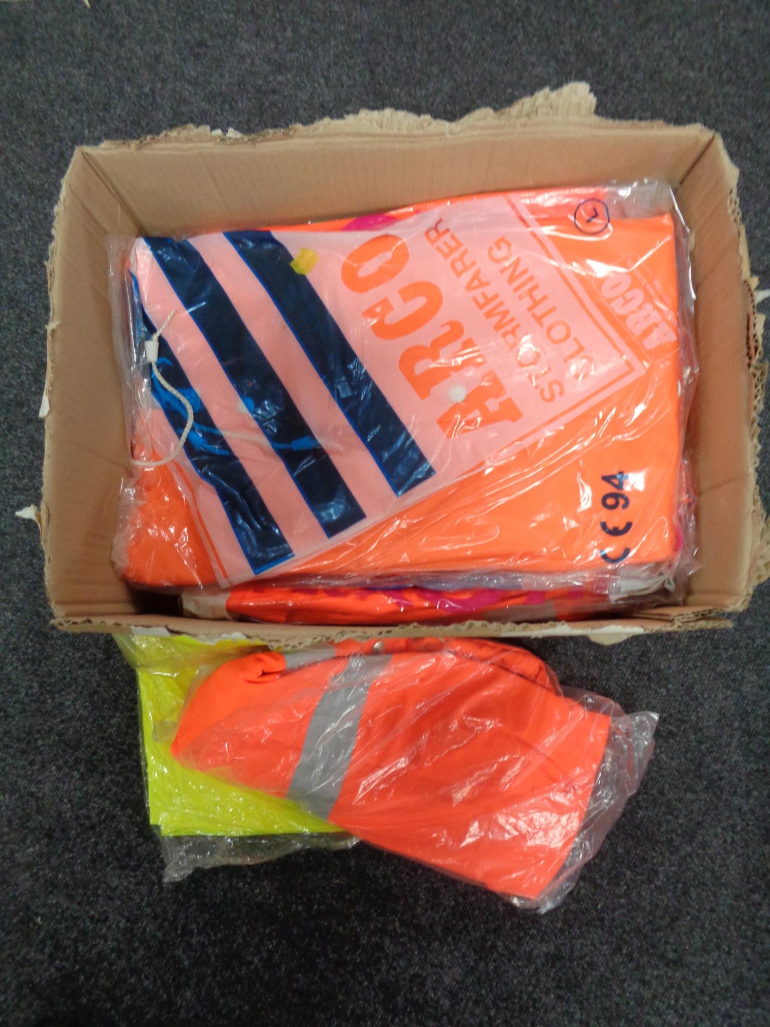 A box of new work clothes - florescent trousers and coats