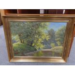 A 20th century gilt framed continental school oil on canvas, river through wooded landscape,