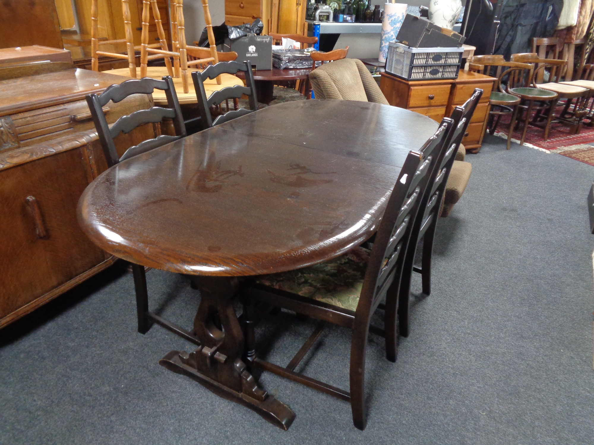 An oval refectory extending table and four rail back chairs