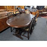 An oval refectory extending table and four rail back chairs