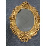 A decorative gilt framed oval cherub mirror