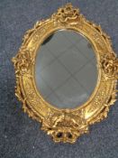 A decorative gilt framed oval cherub mirror