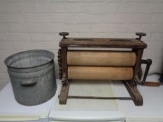 A galvanized twin handled bucket together with a vintage table top mangle