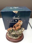 A Border Fine Arts figure of a fox with cubs on rock, on wooden stand,