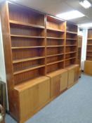 A four piece mid 20th century teak bookcase fitted double door cupboards beneath