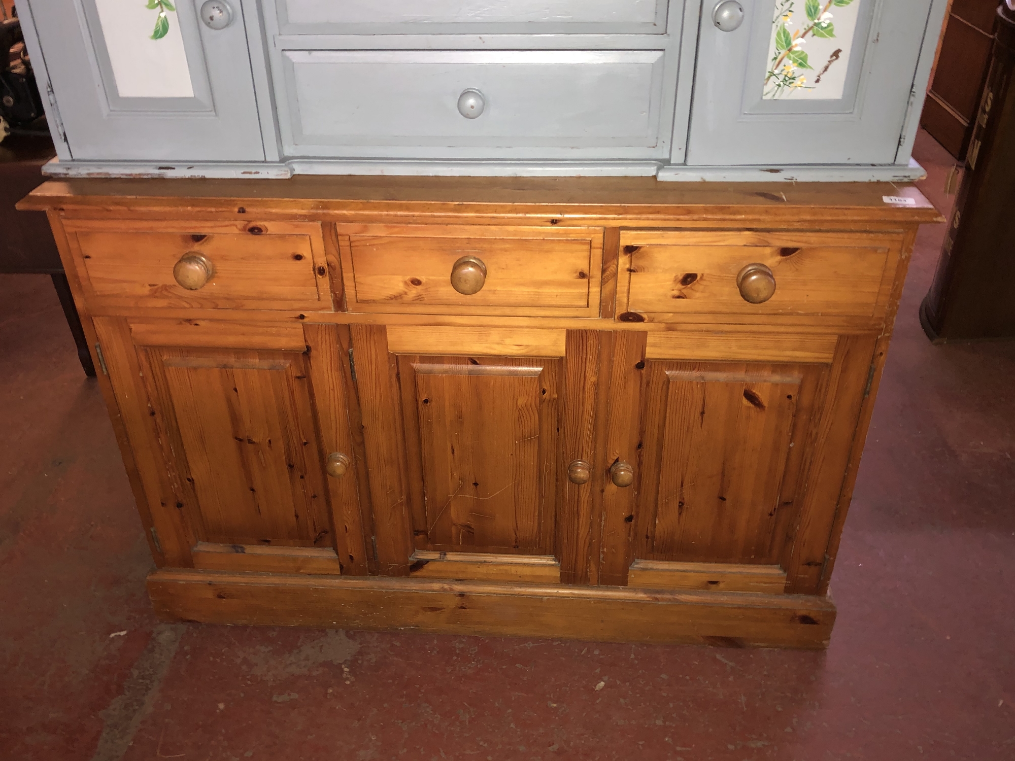 A pine triple door sideboard fitted with three drawers