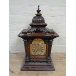 An Edwardian stained pine bracket clock with brass and silvered dial