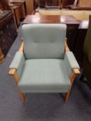 A 20th century oak framed armchair upholstered in a green fabric