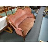 A late 19th century shaped mahogany framed settee upholstered in a pink dralon fabric