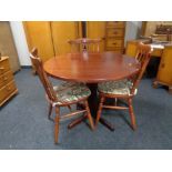 A stained pine kitchen table and three chairs