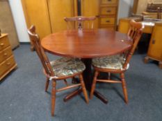 A stained pine kitchen table and three chairs
