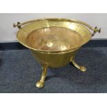 An antique brass Art Nouveau coal bucket on raised legs