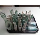 A tray of assorted antique glass bottles