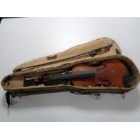 An early 20th century violin and bow in coffin case, needing attention, back length 33 cm.