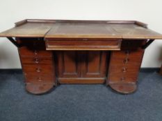An unusual Victorian mahogany writing desk with tooled leather inset panel with fifteen drawers and