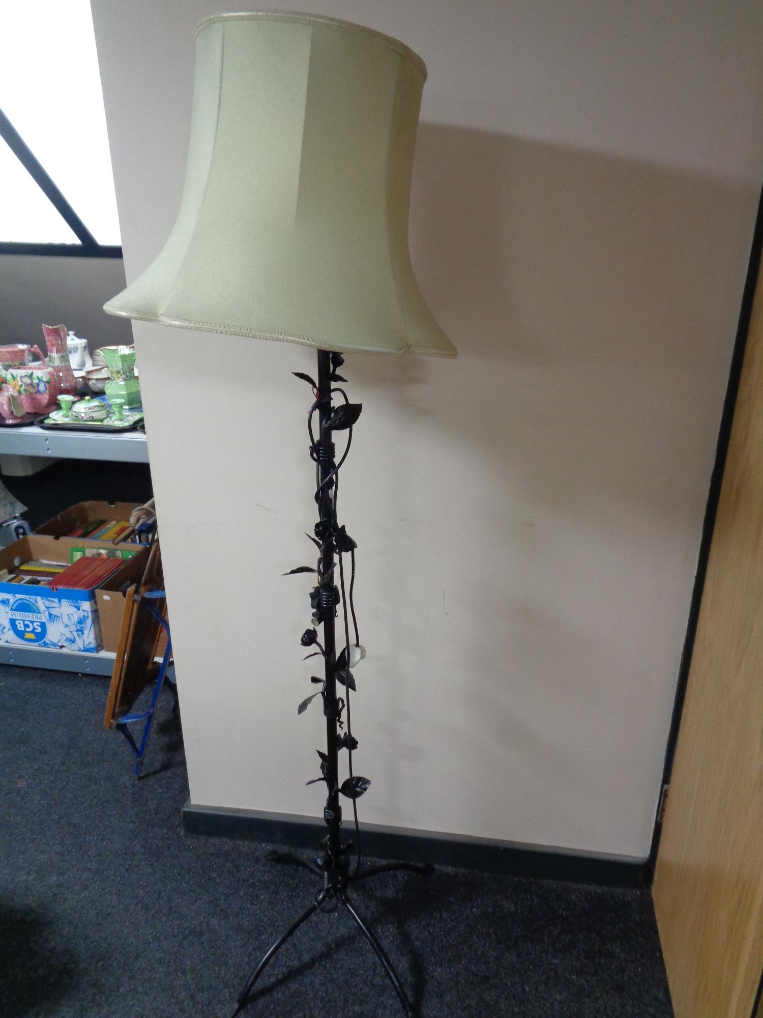 A wrought metal standard lamp of flower design with shade