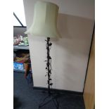 A wrought metal standard lamp of flower design with shade