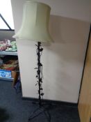 A wrought metal standard lamp of flower design with shade