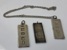 A silver ingot pendant on chain, together with two similar pendants.