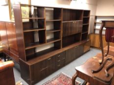 A three section mid 20th century Danish bookcase fitted cupboards and drawers beneath
