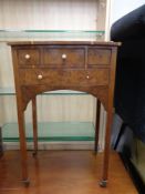 An early 20th century walnut side table fitted four drawers