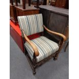 A 20th century oak armchair upholstered in a striped covering