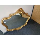 A shaped gilt framed overmantel mirror