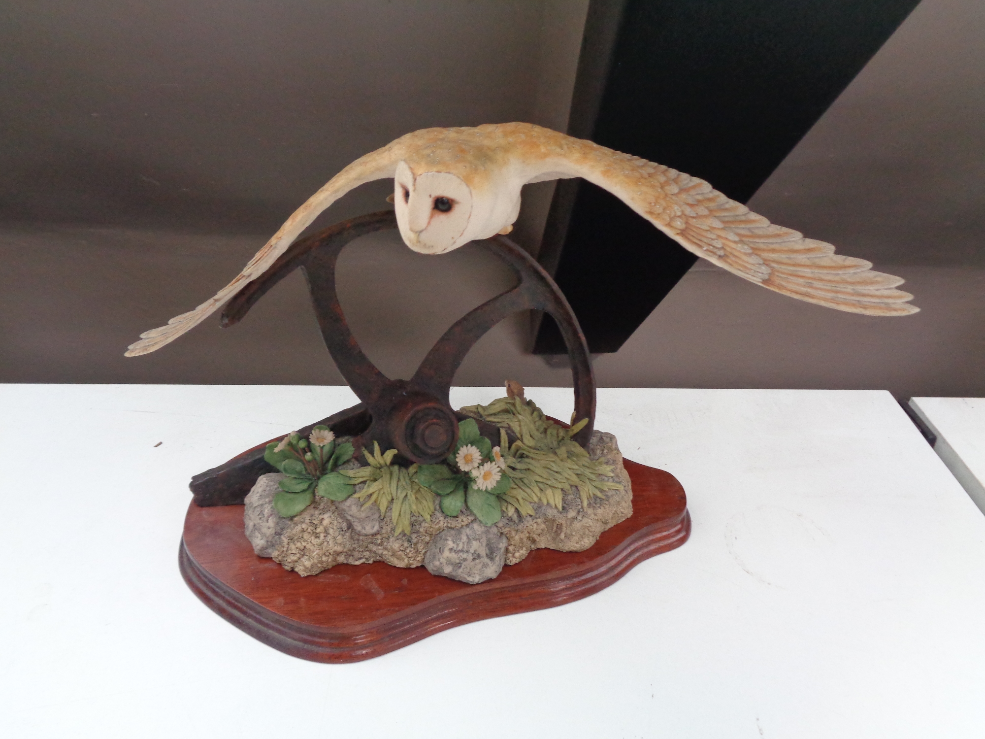 A Border Fine Arts figure of a barn owl taking flight on wooden stand