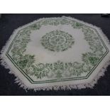 Two hexagonal green floral pattern rugs on cream ground