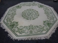 Two hexagonal green floral pattern rugs on cream ground
