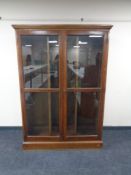 A late 19th century oak glazed door bookcase with adjustable shelves,
